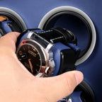 Hand placing a luxury watch onto a black and blue leather Aevitas watch winder with silver accents.