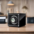 Aevitas single watch winder in high-gloss piano black with a luxury automatic watch displayed inside on a wooden desk.
