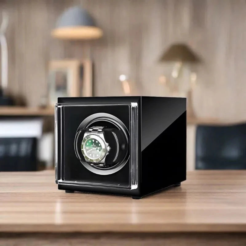 Aevitas single watch winder in high-gloss piano black with a luxury automatic watch displayed inside on a wooden desk.