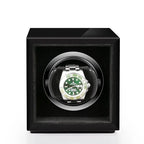 Aevitas single watch winder in high gloss piano black with a silver-accented interior holding a green Rolex watch.
