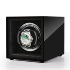 Aevitas high gloss piano black single watch winder with a silver-trimmed interior holding a green automatic watch.