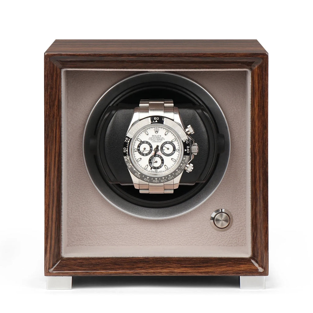 Single watch winder in glossy ebony Macassar wood finish with a silver-faced chronograph watch on a soft beige interior.