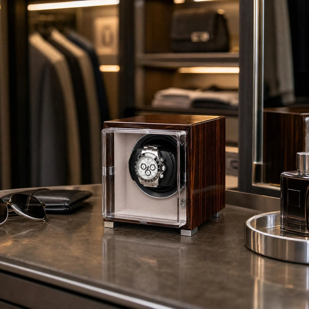 Single watch winder in glossy ebony Macassar wood finish with a clear display case holding a luxury automatic watch.