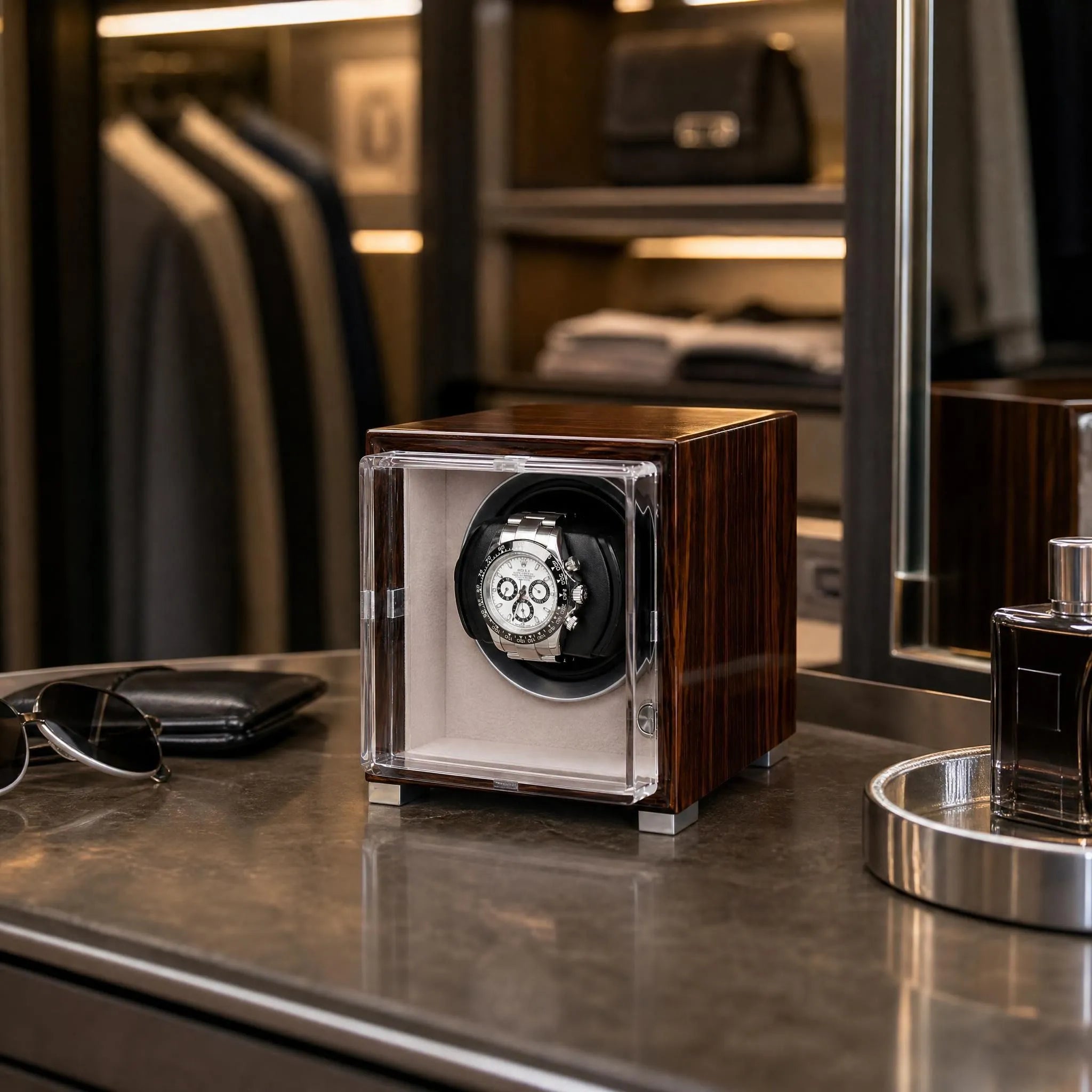 Single watch winder in glossy ebony Macassar wood finish with a clear display case holding a luxury automatic watch.