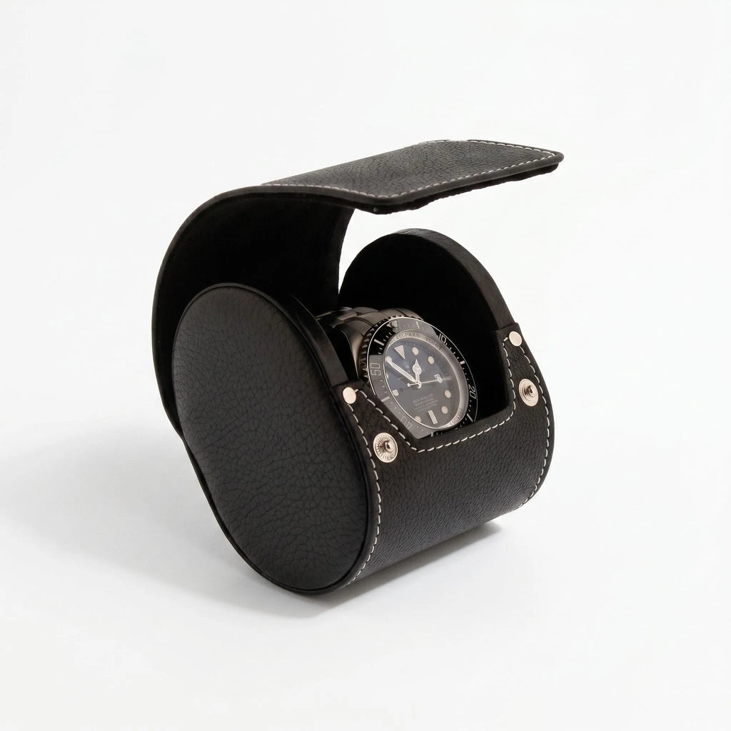 Black genuine leather watch travel case by Aevitas with soft lining, protecting watches during travel, shown with a shadow highlighting texture and quality.