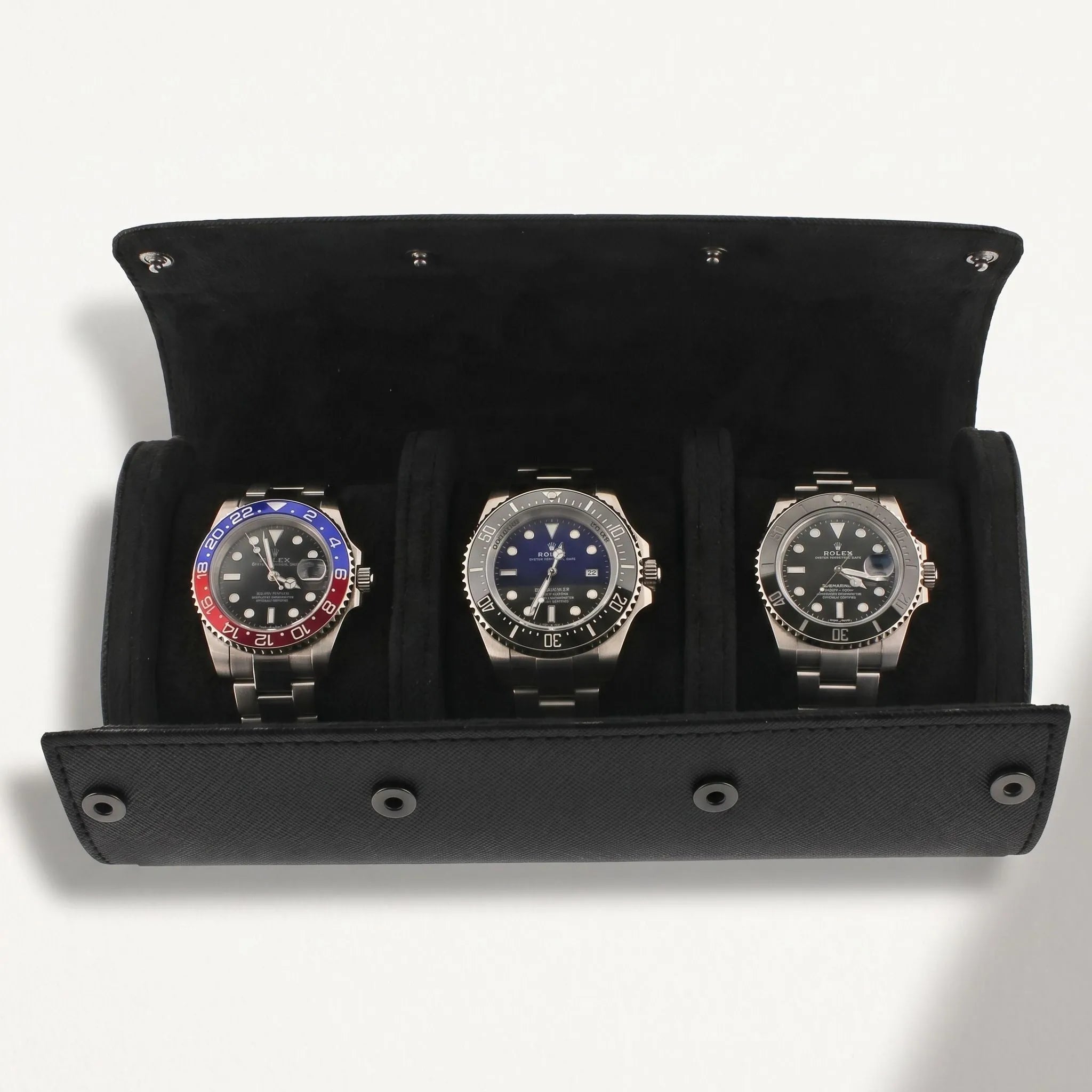 Elegant black vegan leather watch roll with suede lining, designed for safe storage of multiple watches during travel, with a shadow from natural lighting.