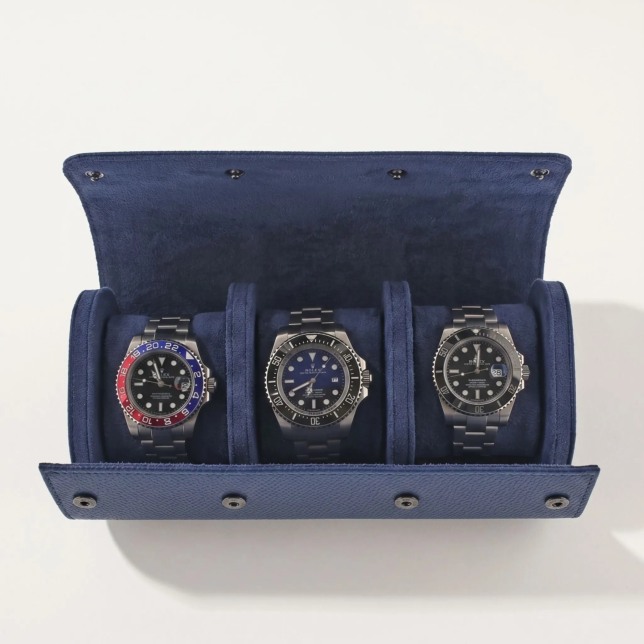 Elegant blue leather triple watch roll with soft suede lining, designed for travel and watch protection, featuring fine craftsmanship.