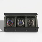 Luxurious triple watch roll in carbon fibre vegan leather with green lining and metal closures, displayed without background with gentle shadow.
