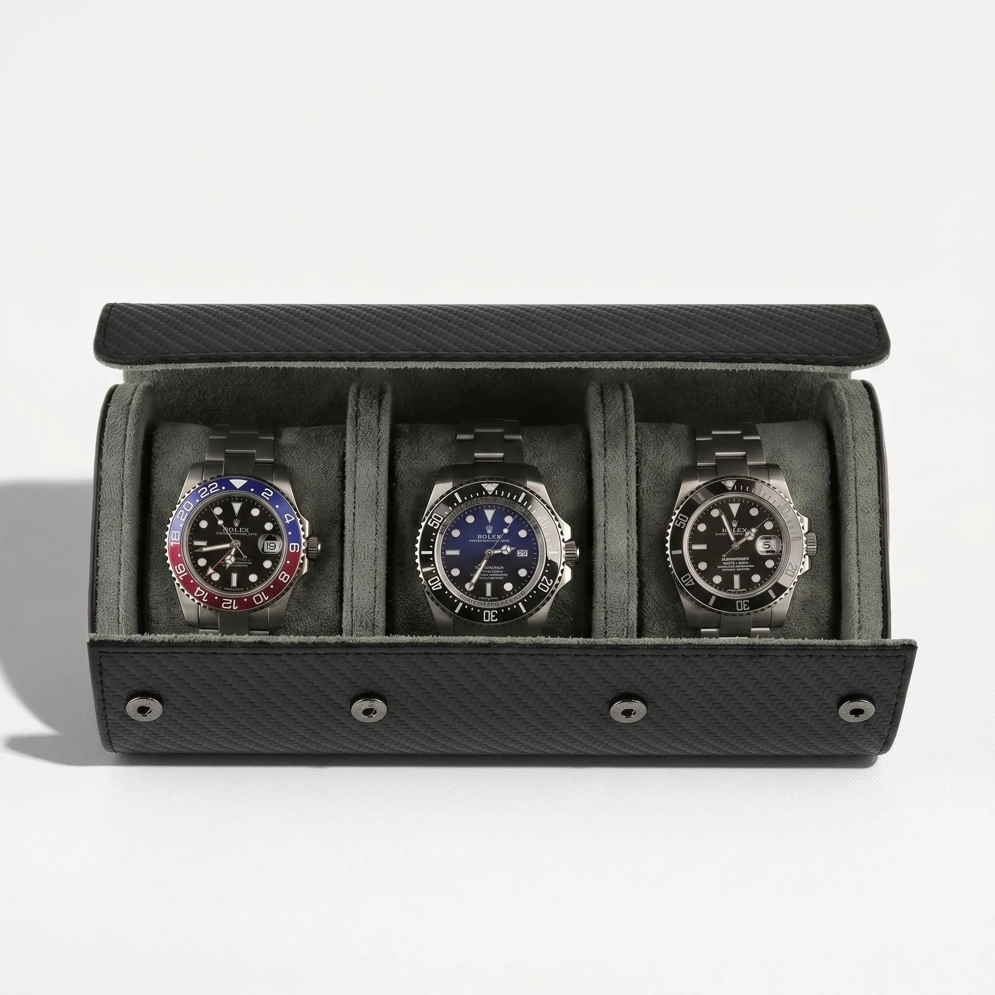 Luxurious triple watch roll in carbon fibre vegan leather with green lining and metal closures, displayed without background with gentle shadow.
