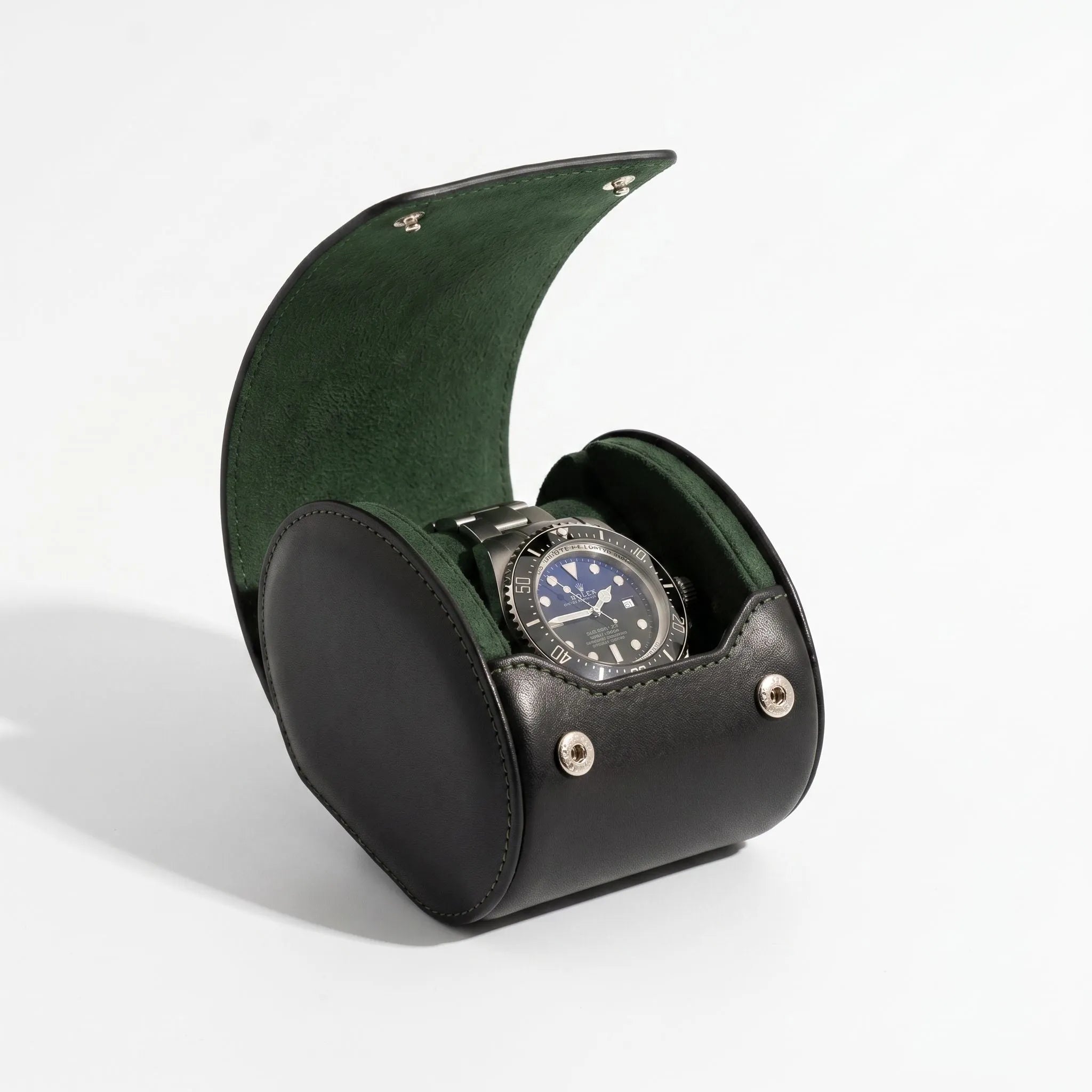 Single watch roll case in black Nappa leather with green Alcantara lining, showcased on a white surface with a gentle light and shadow effect.