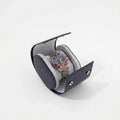 Close-up of navy blue saffiano leather watch roll with soft lighting and subtle shadow on a white background.